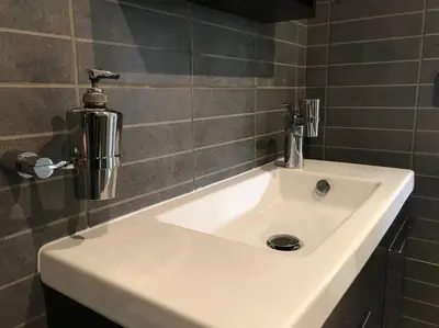 a bathroom sink with a soap dispenser on top of it at NATURE & SEA in Saronida