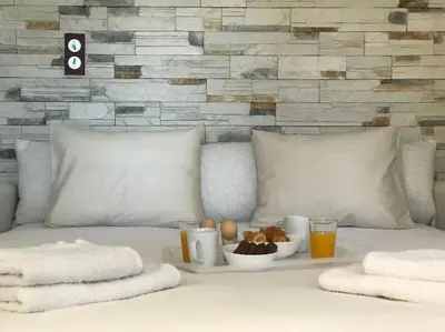 a white bed with a tray of food and drinks at NATURE & SEA in Saronida