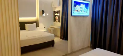 a small bedroom with a bed and a mirror at Mirada Hotel in Athens