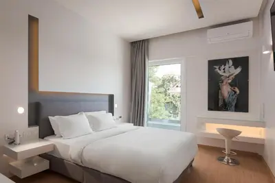 a bedroom with a large white bed and a window at Mirada Hotel in Athens