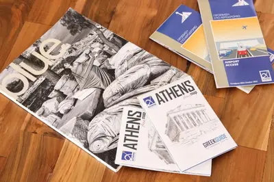 a magazine sitting on top of a wooden table at Πολυτελές διαμέρισμα-Πασαλιμάνι in Piraeus