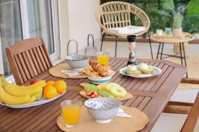 a wooden table with plates of fruit and drinks on it at Πολυτελές διαμέρισμα-Πασαλιμάνι in Piraeus