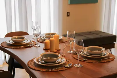 a wooden table with plates and wine glasses on it at Πολυτελές διαμέρισμα-Πασαλιμάνι in Piraeus