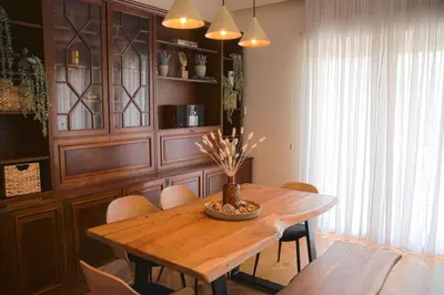 a dining room with a wooden table and chairs at Πολυτελές διαμέρισμα-Πασαλιμάνι in Piraeus