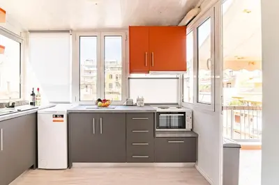 a kitchen with gray cabinets and a white refrigerator at Under the Hill in Athens