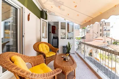 a balcony with wicker chairs and a table at Under the Hill in Athens