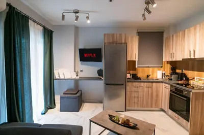 a kitchen with a refrigerator and a table in a room at Lux Modern Apt Ανακαινισμένο διαμέρισμα 150m από την πλαζ 'ΈΔΕΜ' in Athens