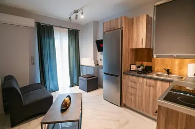 a kitchen with a couch and a chair in a room at Lux Modern Apt Ανακαινισμένο διαμέρισμα 150m από την πλαζ 'ΈΔΕΜ' in Athens