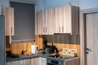 a kitchen with wooden cabinets and a sink at Lux Modern Apt Ανακαινισμένο διαμέρισμα 150m από την πλαζ 'ΈΔΕΜ' in Athens