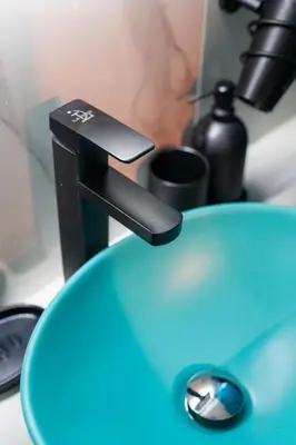 a close up of a bathroomaucet with a blue sink at Lux Modern Apt Ανακαινισμένο διαμέρισμα 150m από την πλαζ 'ΈΔΕΜ' in Athens