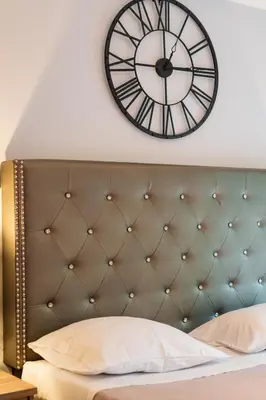 a large clock on the wall above a bed at Lux Modern Apt Ανακαινισμένο διαμέρισμα 150m από την πλαζ 'ΈΔΕΜ' in Athens