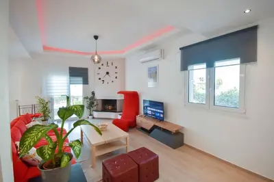 a living room with a couch and a red chair at Cozy Cloud Apartment in Markopoulo