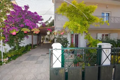 a building with flowers and plants in front of it at Cozy Cloud Apartment in Markopoulo