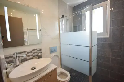 a bathroom with a sink and a toilet and a mirror at Cozy Cloud Apartment in Markopoulo