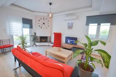 a living room with a red couch and a table at Cozy Cloud Apartment in Markopoulo