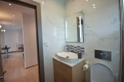 a bathroom with a sink and a toilet and a mirror at Cozy Cloud Apartment in Markopoulo