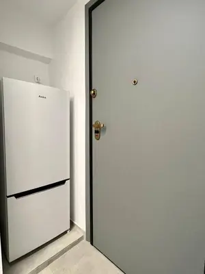 a white refrigerator next to a door in a room at Attiki Apartment VIPGreece in Athens