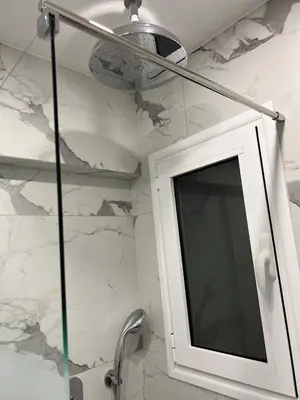 a bathroom with a shower with a mirror and a sink at Attiki Apartment VIPGreece in Athens