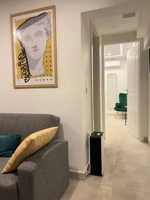 a living room with a couch and a painting on the wall at Attiki Apartment VIPGreece in Athens