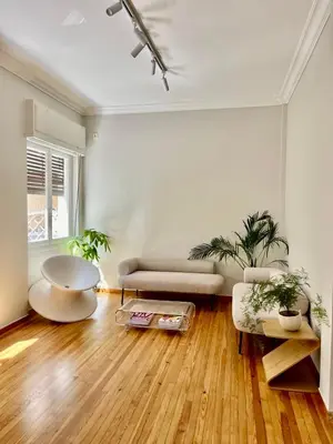 a living room with a couch and two potted plants at Athens Classic Luxury 2-Bedroom Apartment in Athens