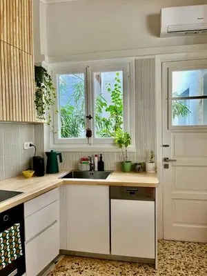 a kitchen with white cabinets and a sink and two windows at Athens Classic Luxury 2-Bedroom Apartment in Athens