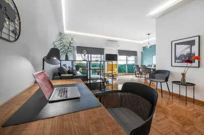 a living room with a table with a laptop on it at Spacious & bright 2br apt in hip Pangrati, Athens in Athens