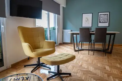 a living room with a chair and a table at Spacious & bright 2br apt in hip Pangrati, Athens in Athens
