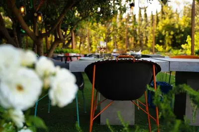 a table with a black chair and some white flowers at Spacious & bright 2br apt in hip Pangrati, Athens in Athens