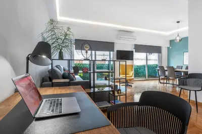 a living room with a table with a laptop on it at Spacious & bright 2br apt in hip Pangrati, Athens in Athens