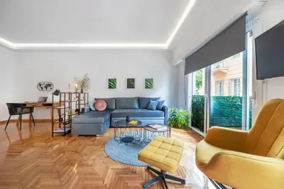 a living room with a blue couch and a table at Spacious & bright 2br apt in hip Pangrati, Athens in Athens