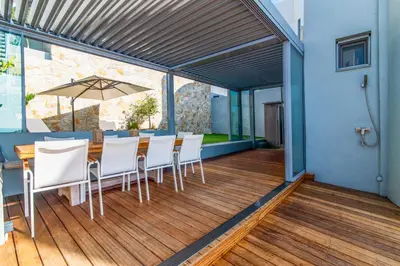 a dining room with a table and white chairs at Villa Azzura with sea view & private pool at Athens Riviera in Aghia Marina
