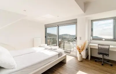 a white bedroom with a bed and a window at Villa Azzura with sea view & private pool at Athens Riviera in Aghia Marina