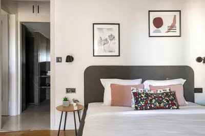 a bedroom with a bed with white sheets and pink pillows at Zeus 2-Bedroom Apartment in Athens in Athens