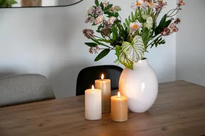 a table with three candles and a vase with flowers at Zeus 2-Bedroom Apartment in Athens in Athens