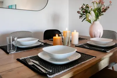 a wooden table with plates and candles on it at Zeus 2-Bedroom Apartment in Athens in Athens
