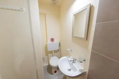 a bathroom with a white toilet and a sink at PURE URBAN BEDBOXES ACROPOLIS METRO PETRALONA in Athens