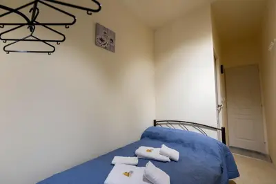 a bedroom with a blue bed with towels on it at PURE URBAN BEDBOXES ACROPOLIS METRO PETRALONA in Athens