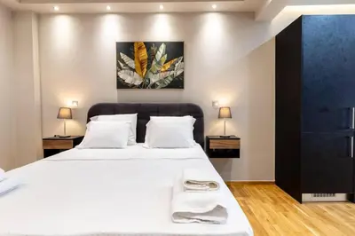 a bedroom with a large white bed with two lamps at Acropolis lux view penthouse in Athens