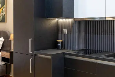 a kitchen with brown cabinets and a counter top at Acropolis lux view penthouse in Athens