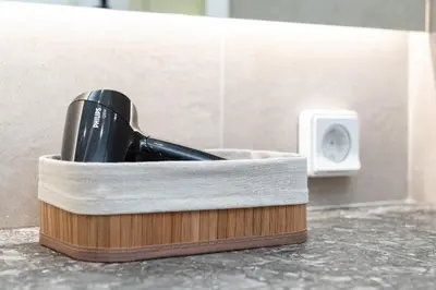 a hair dryer in a wooden holder next to a wall at Twins apartments - museum in Athens