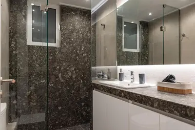 a bathroom with a sink and a glass shower at Twins apartments - museum in Athens