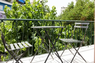 two chairs and a table on a balcony at Twins apartments - museum in Athens