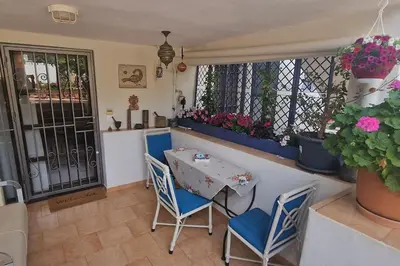 a small table and chairs in a room with flowers at Villa Aura - Thymari in Sounio
