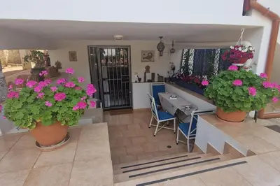 a room with two potted plants and a table and chairs at Villa Aura - Thymari in Sounio