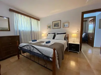a bedroom with a large bed and a large window at Villa Aura - Thymari in Sounio