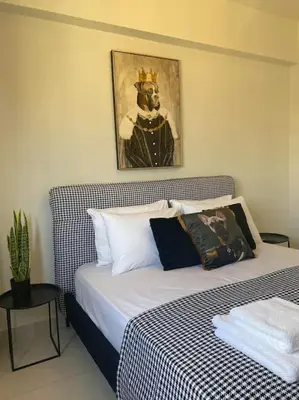 a bedroom with a bed with a painting on the wall at New 2BD aprt with Shared Rooftop Pool D3 in Athens