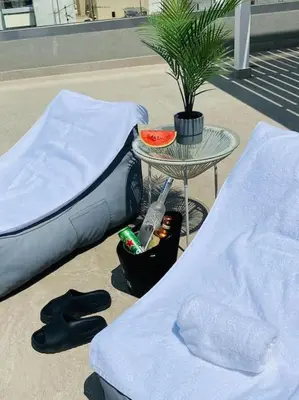 a bed and a table next to a table with a plant at New 2BD aprt with Shared Rooftop Pool D3 in Athens