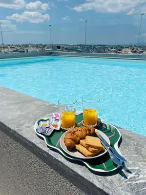 a tray of food on a table next to a swimming pool at New 2BD aprt with Shared Rooftop Pool D3 in Athens