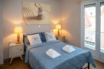 a bedroom with a blue bed with towels on it at Acropolis Terrace View Apartment in Athens