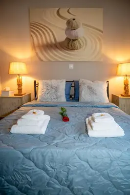 a blue bed with towels on top of it at Acropolis Terrace View Apartment in Athens